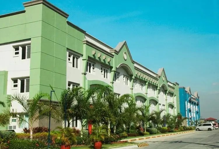 Rainbow Ridge Condominiums building facade by day, a three-story green and white DMCI Homes low-rise condo building behind palms and planted beds in Barangay Hagonoy, Taguig City, actual photo